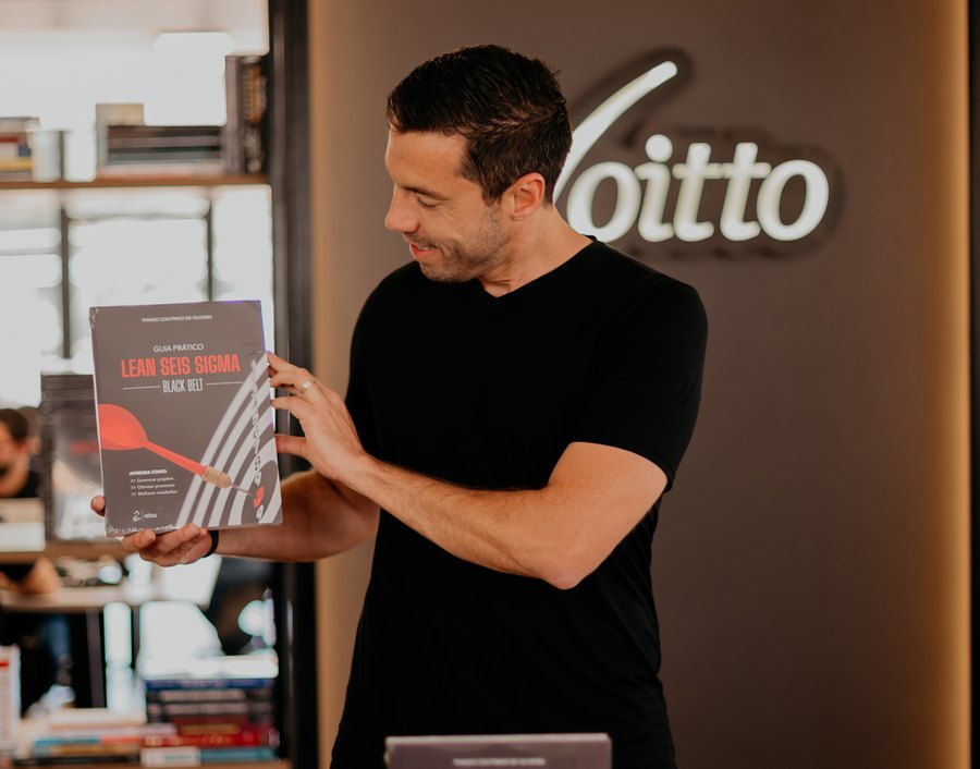 Thiago Coutinho segurando o livro Guia Prático Lean Seis Sigma